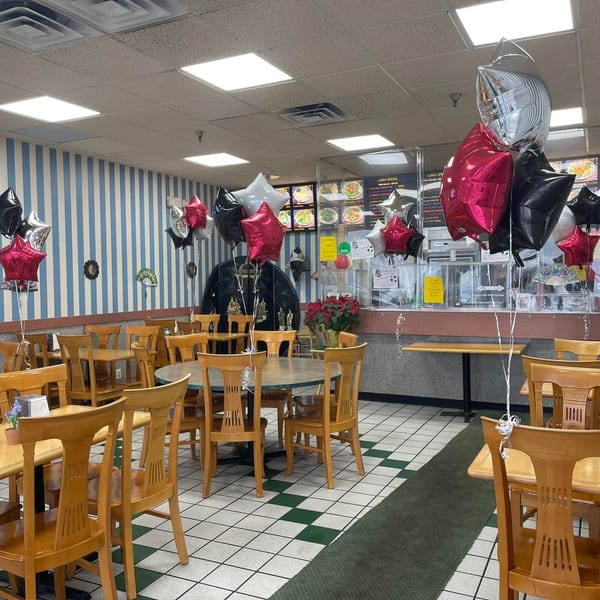 China Wok dining room with blue and white striped walls, wooden tables, and star-shaped balloons.